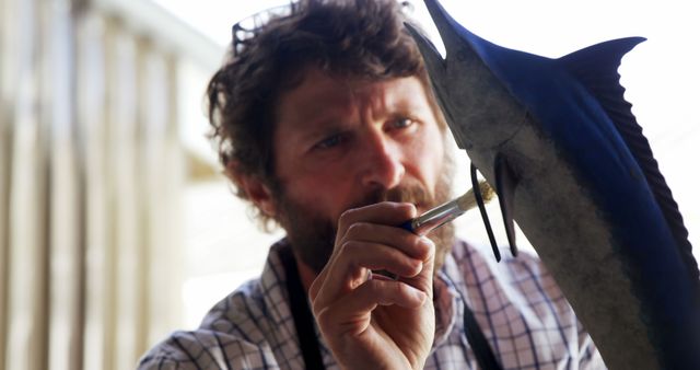 Focused Artisan Painting a Metallic Fish Sculpture Indoors - Download Free Stock Images Pikwizard.com