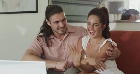 Happy couple engaged in online communication on laptop