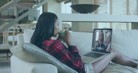 Biracial Woman Enjoying Virtual Coffee Chat on Laptop