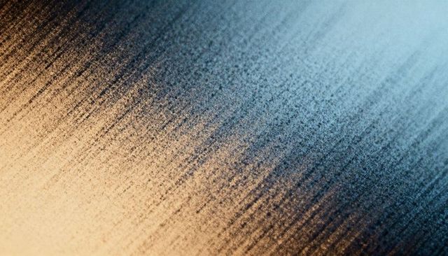 Granular brushed texture featuring diagonal streaks warm-to-cool gradient speckled surface