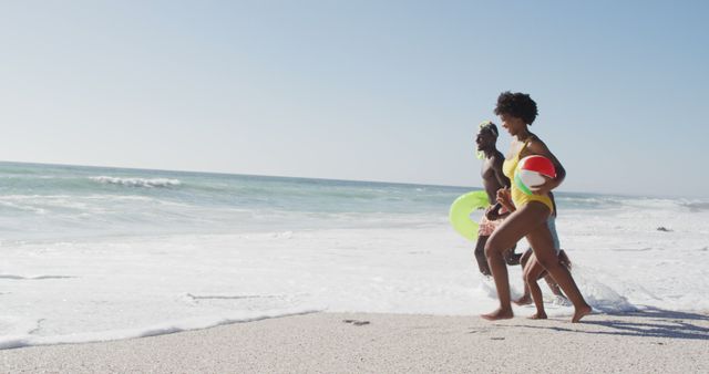 Happy friends running on beach with flotation devices - Download Free Stock Images Pikwizard.com