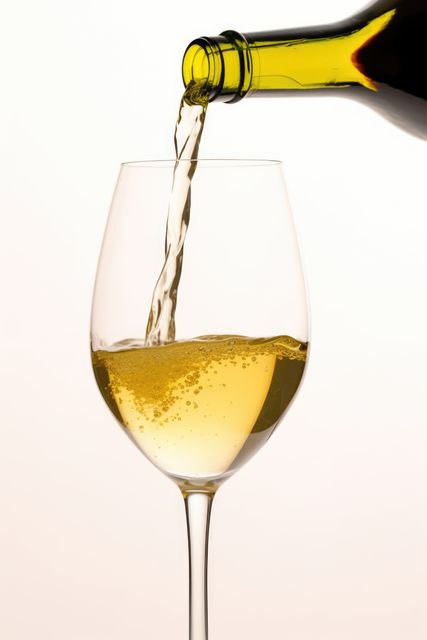 White wine pouring to glass from bottle on white background, created using generative ai technology. Wine week, drink, alcohol and wine tasting awareness concept digitally generated image.
