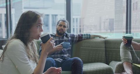 Colleagues Relaxing in Office Lounge with Coffee