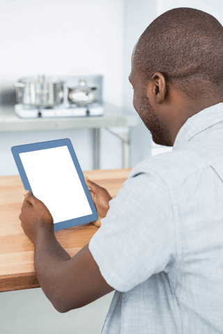 man viewing transparent tablet screen at wooden kitchen table - Download Free Stock Videos Pikwizard.com