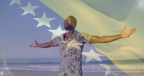 Joyful Man Embracing Freedom on Beach with National Pride