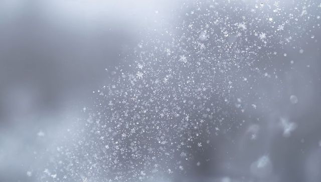 Diagonal drift of delicate six-armed snowflakes through overcast air with bokeh motion