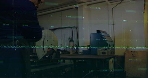 Industrial worker grinding metal with data overlay in workshop