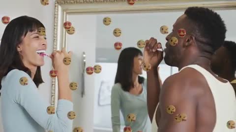 Smiling Couple Brushing Teeth with Love Emojis Reflecting in Mirror