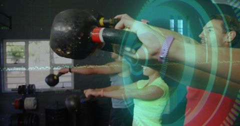 Group training pressing kettlebells wearing neon and red tops with futuristic hud overlay