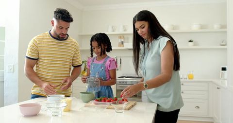 Happy Family Preparing Fresh Strawberry Dish in Modern Kitchen