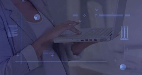 Mid-adult woman holding laptop typing with futuristic blue hud overlay and data charts
