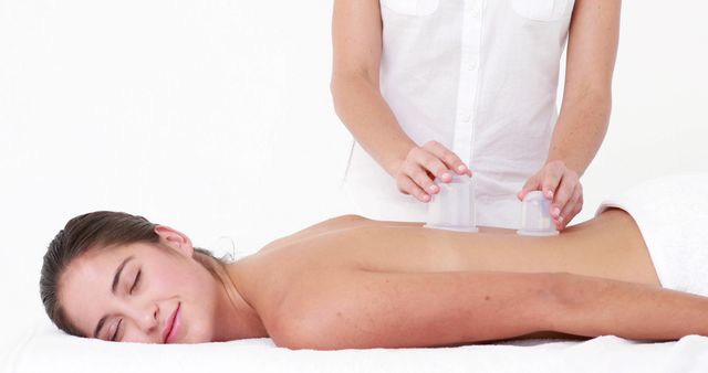 A young Caucasian woman enjoys a relaxing massage from a therapist, with copy space. The scene captures a moment of tranquility and wellness in a spa setting.