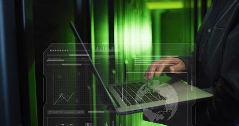 Mature Korean IT engineer typing on laptop in data center with green HUD overlay
