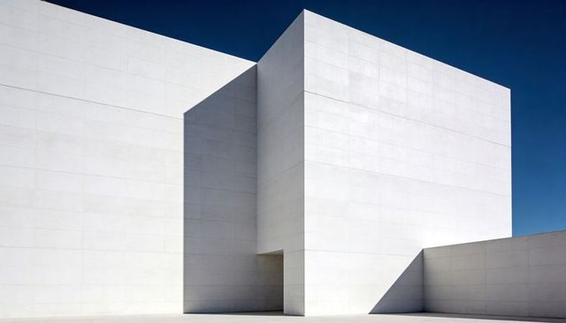 Minimalist White Concrete Cube Building with Sharp Shadow Planes and Recessed Entrance