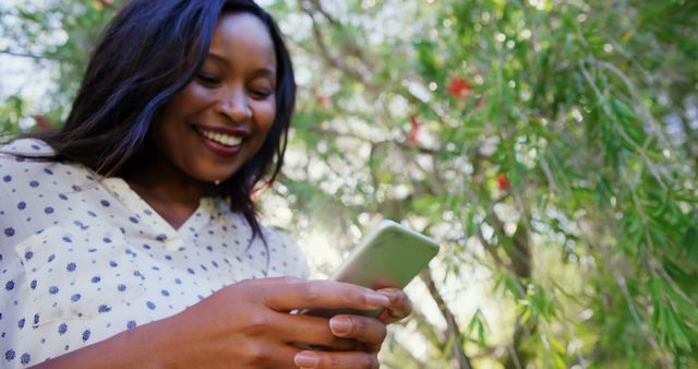 Smiling Woman Using Smartphone in Sunny Outdoor Garden - Download Free Stock Images Pikwizard.com