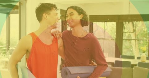 Happy Gay Couple Embracing with Yoga Mats at Home