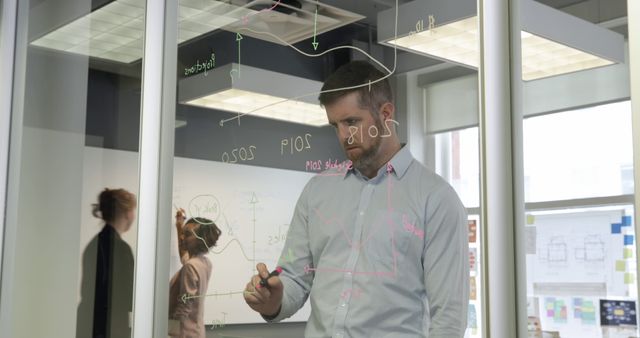 Business Professional Analyzing Data on Transparent Glass Board - Download Free Stock Images Pikwizard.com