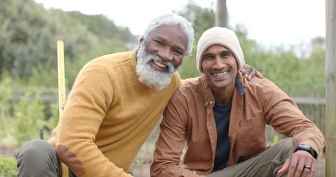 Multicultural Friends Gardening Together Smiling and Embracing in Home Backyard Garden