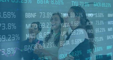 Businesswomen analyzing stock market tickers on transparent glass display with tablet
