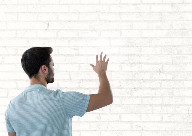 Digital composite of Man touching white wall