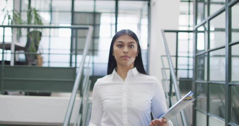 Confident professional walking through modern office environment