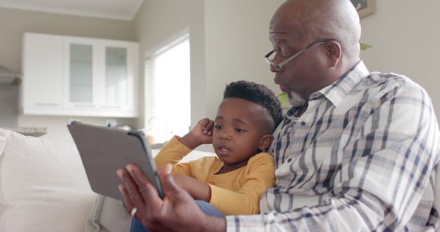 Grandfather and Grandson Using Digital Tablet Together on Couch - Download Free Stock Images Pikwizard.com