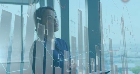 Asian Woman Analyzing Financial Data in Modern Office Environment