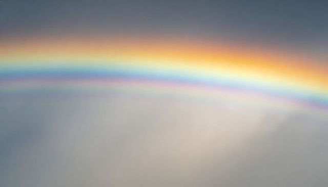 Prismatic Double Rainbow Arc Stretching Across Soft Cloud Sky with Muted Pastel Spectrum