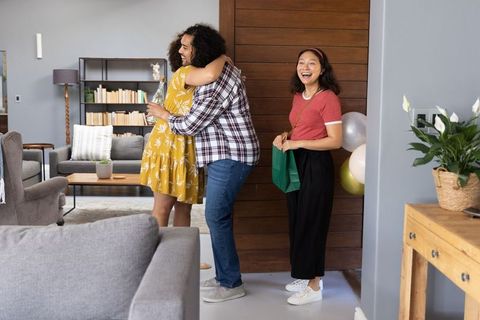 Happy Friends Celebrating Together at Home with Gift Exchange