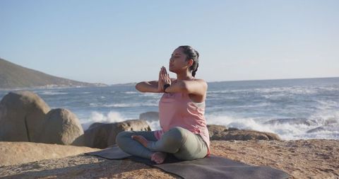 Woman Meditating by the Ocean on a Peaceful Day