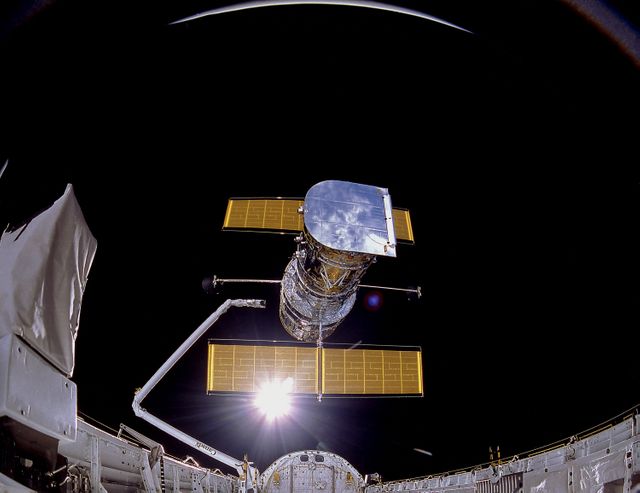 Hubble Space Telescope being deployed into space by Space Shuttle Discovery's crew on April 25, 1990. Great for illustrating topics in astronomy, space exploration, and NASA missions.