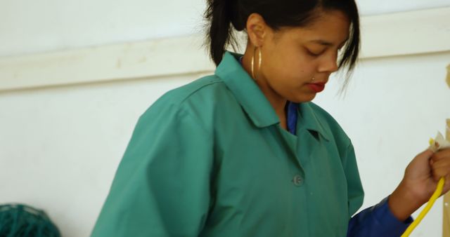 Woman Cleaning Floor with Broom in Green Uniform - Download Free Stock Images Pikwizard.com