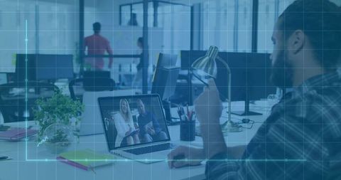 Professional collaborating in virtual meeting in open-plan office