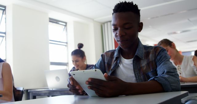 Focused Student Using Digital Tablet in Classroom - Download Free Stock Images Pikwizard.com