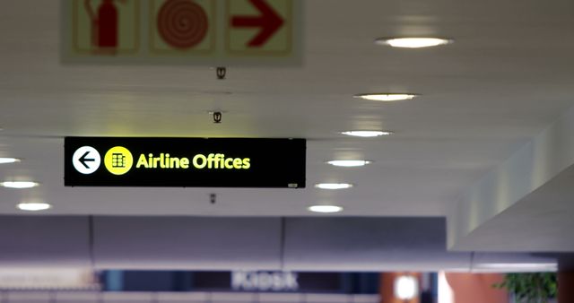 Directional sign showing the way to airline offices in a modern airport terminal, highlighted under illuminated ceiling lights. Ideal for promoting air travel services, airport amenities, transportation infrastructure, and travel information websites. Can be used in articles related to travel tips, airport navigation, and airline services.