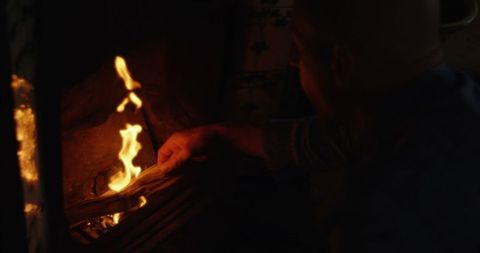 Man Adding Logs to Fireplace for Cozy Home Ambiance - Download Free Stock Images Pikwizard.com