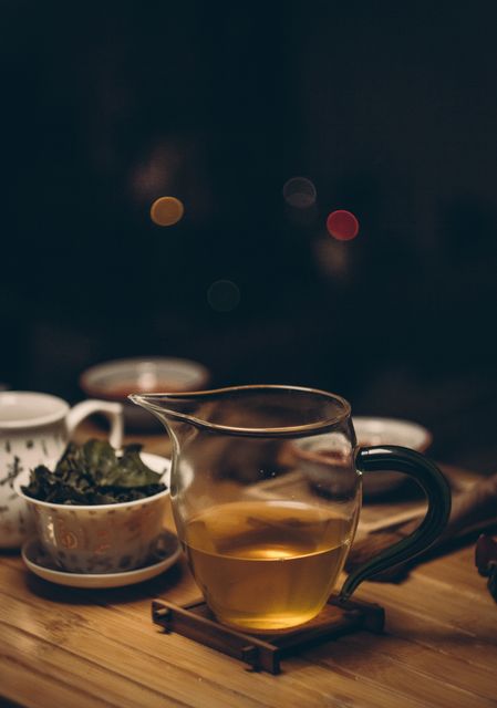 Warm Herbal Tea in Glass Pitcher on Wooden Table at Night - Download Free Stock Photos Pikwizard.com