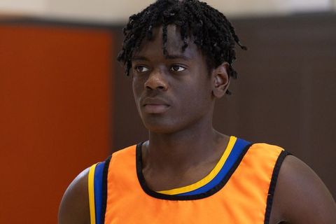 Teenage Male Athlete Wearing Practice Jersey in Gym Setting