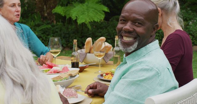 Smiling Senior Man Enjoying Outdoor Meal with Friends - Download Free Stock Images Pikwizard.com