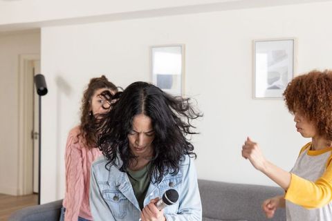 Friends singing home jam session trio rehearsing with handheld microphone
