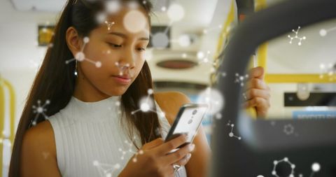 Asian Woman Engaging with Smartphone and Molecular Graphics