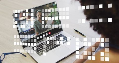Presenting paper during virtual meeting on laptop with digital interface and workspace