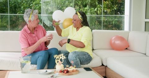 Happy Senior Lesbian Couple Celebrating Birthday on Outdoor Terrace