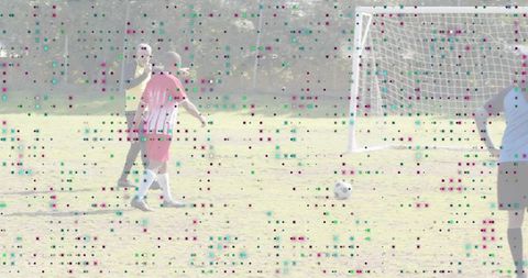 Walking red-jersey player approaching soccer ball near goal during outdoor training session
