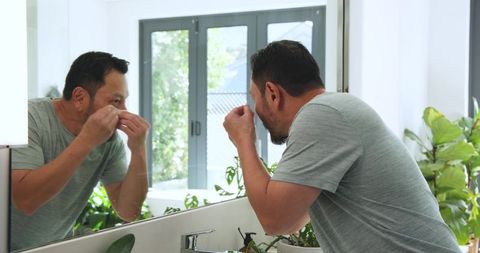Man Practicing Self-Care at Bathroom Mirror