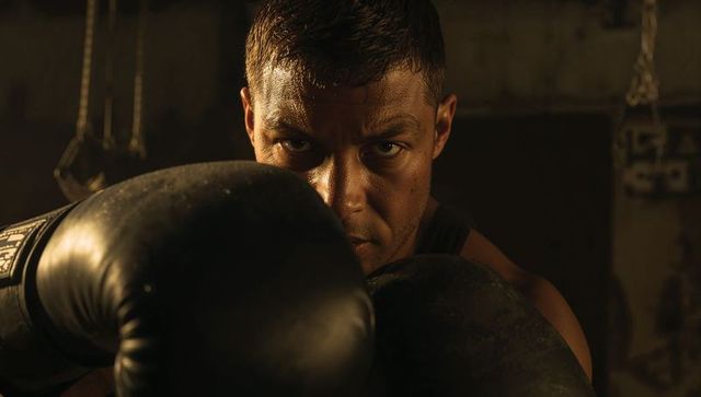 Determined male boxer training in rustic gym