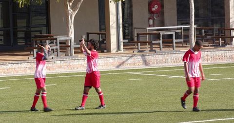 Soccer Player With Teammates and Referee on Sports Field Outdoors