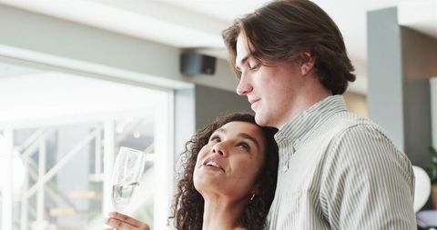 Smiling Couple Toasting with Champagne in Living Room Celebration
