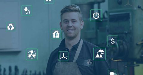 Young Machinist Standing Wearing Leather Apron Dark Shirt Showing Renewable Energy Icons