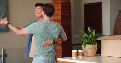 Diverse Gay Couple Dancing Happily in New Home
